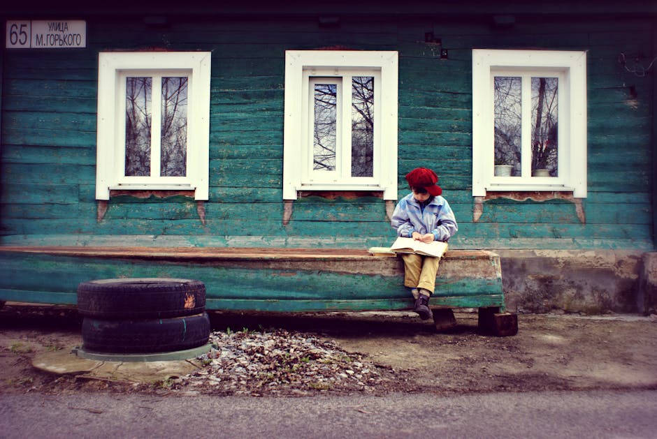 A child reading outside a traditional teal house representing authentic local stays
